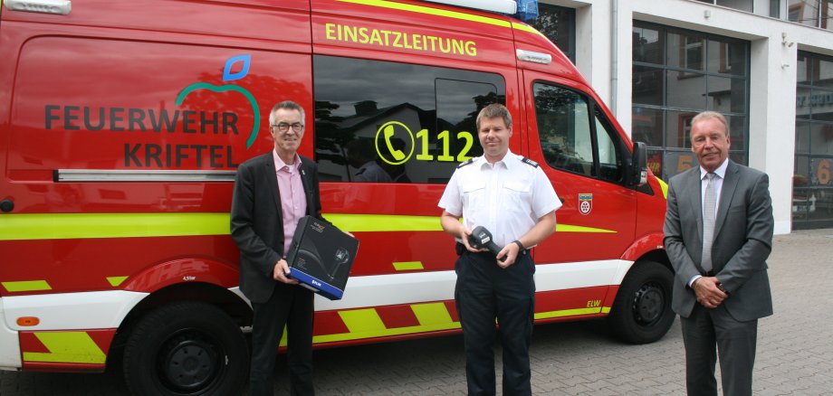 Franz Jirasek, Gemeindebrandinspektor und Dieter Wagenknecht von der Sparkassenversicherung vor einem Feuerwehreinsatzwagen mit der neuen Wärmebildkamera.