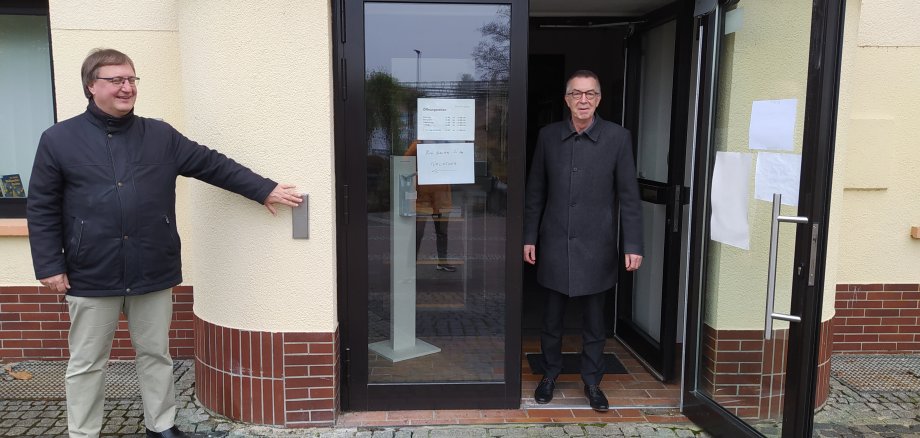 Dr. Frank Fichert öffnet per Wandtaster Franz Jirasek die Tür zur Bücherei.
