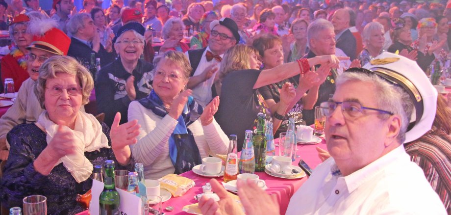 Gutgelaunte Senioren sitzen verkleidet in der GRoßen Schwarzbachhalle.