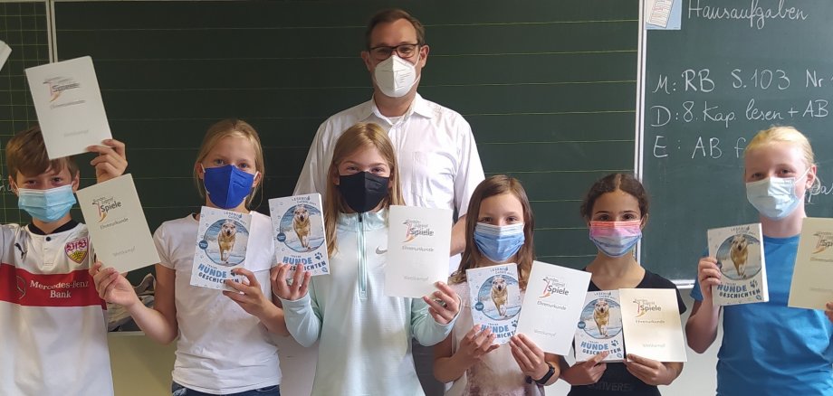 Kinder mit Masken unf Ehrenurkunden mit Bürgermeister Seitz im Klassenraum.