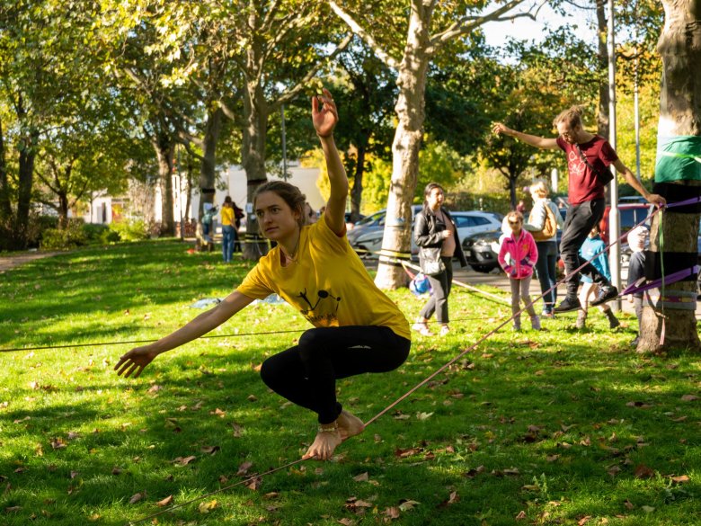 Ein Mädchen balanciert wie ein Profi auf einer Slackline.