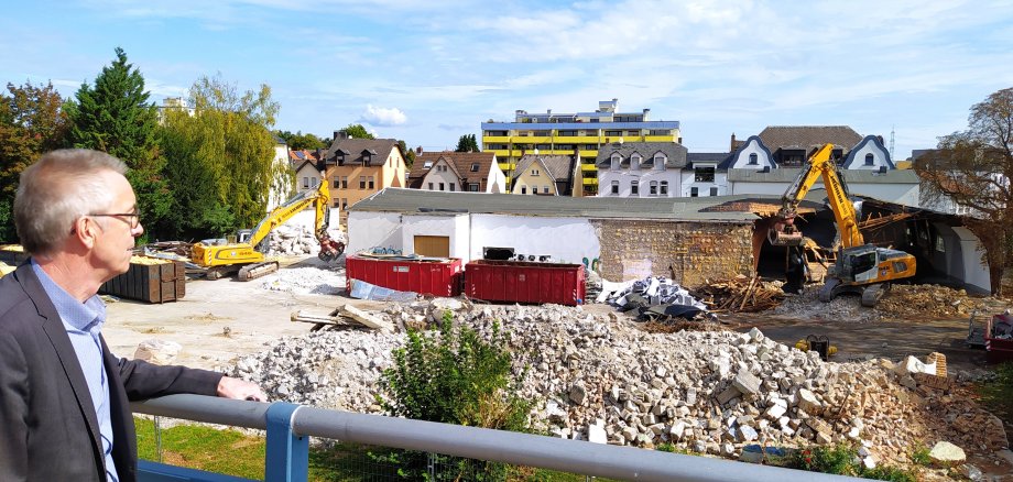 Der Erste Beigeordnete Franz Jirasek schaut von der Eisenbahnbrücke auf die Abrissarbeiten auf dem ehemaligen ROWG-Gelände.