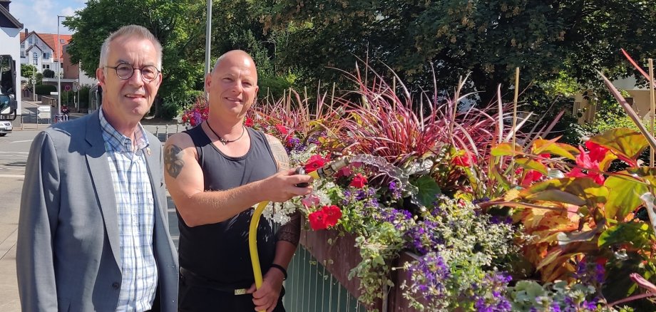 Jirasek und Tänzer an den neubepflanzten Blumenkästen.