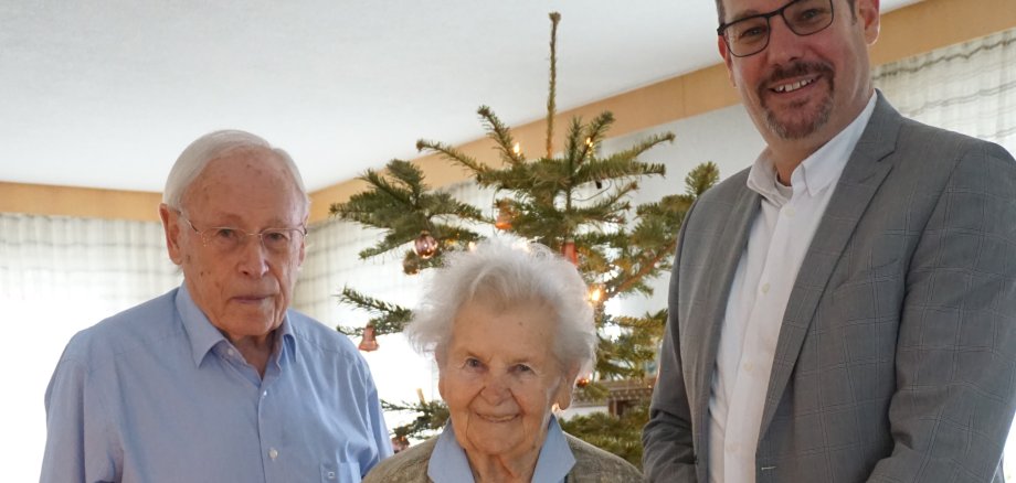 Das Jubelpaar mit Bürgermeister vor dem Tannenbaum.