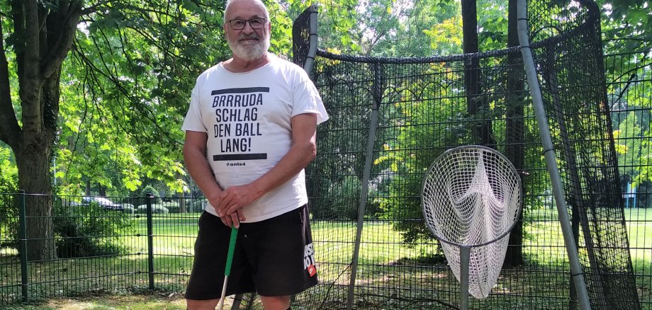 Dieter Veit mit Schläger neben einer Minigolf-Bahn.