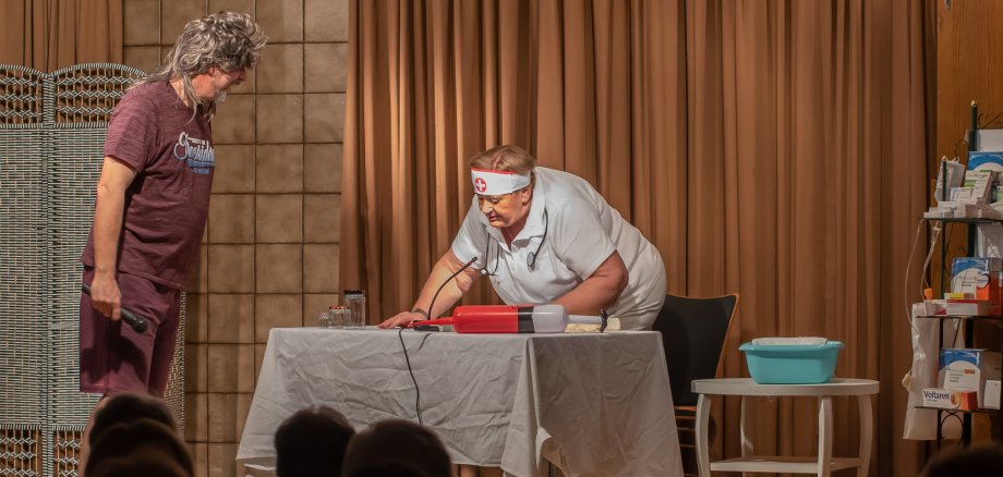 Arztin und Patient auf der Bühne im Rathaus.