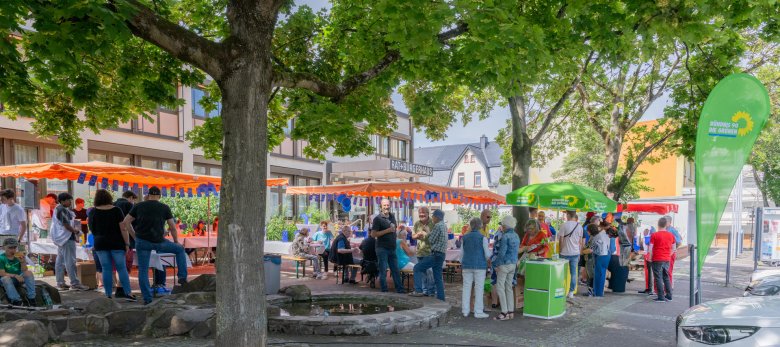 Vor dem Rathaus stehen Schirme und geschmückte Biergarnituren.