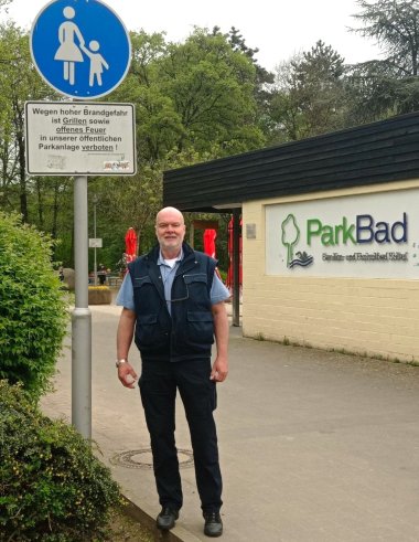 Ordnungspolizist Stefan Lörsch neben einem Gehweg-Schild.