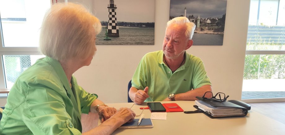 Peter Groß erklärt einer Dame ihr Handy.