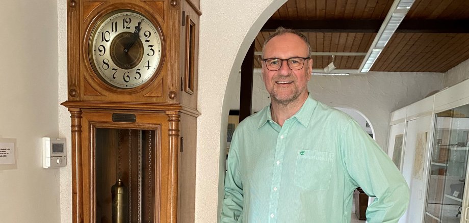 Dr. Krause neben einer alten Standuhr im Museum.