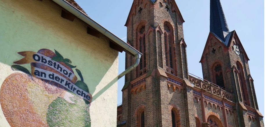 Ein Ausschnitt aus dem Film: Obsthof mit Kirche.