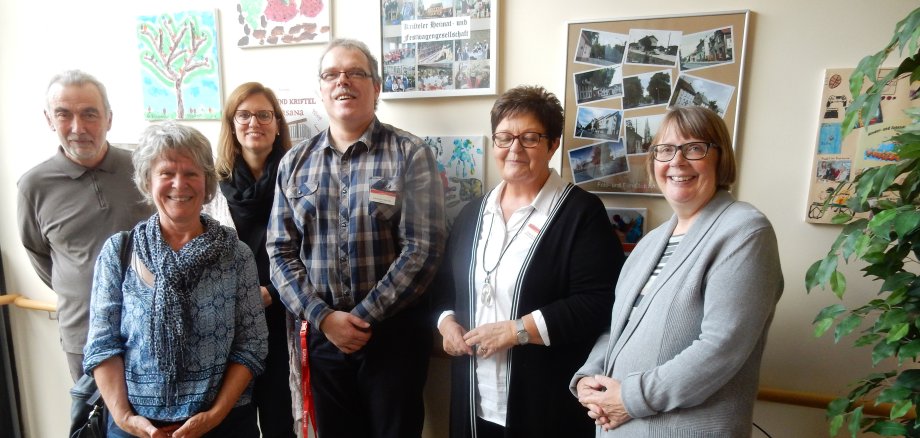 Die Leitung des Seniorenpflegeheims mit Vereinsvertretern vor der neuen Bilderwand.