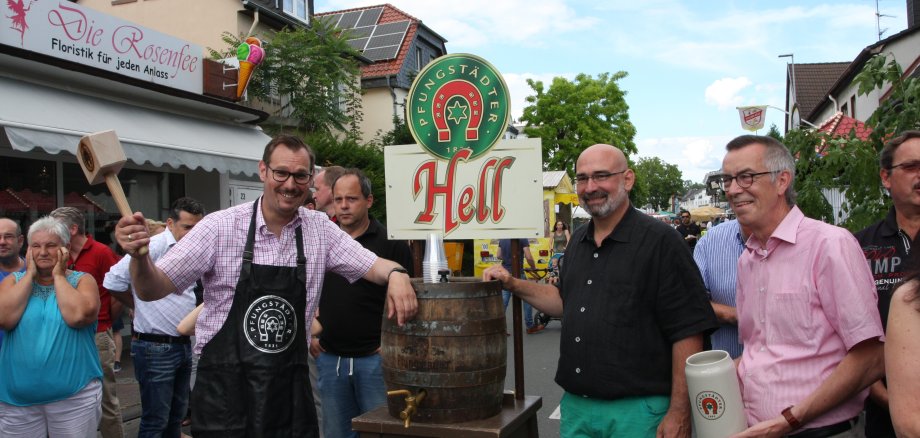 Bürgermeister Christian Seitz holt mit dem Hammer zum Faßanstich aus.