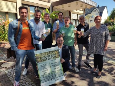 <Das Orgateam mit Plakat vor dem Rathaus.