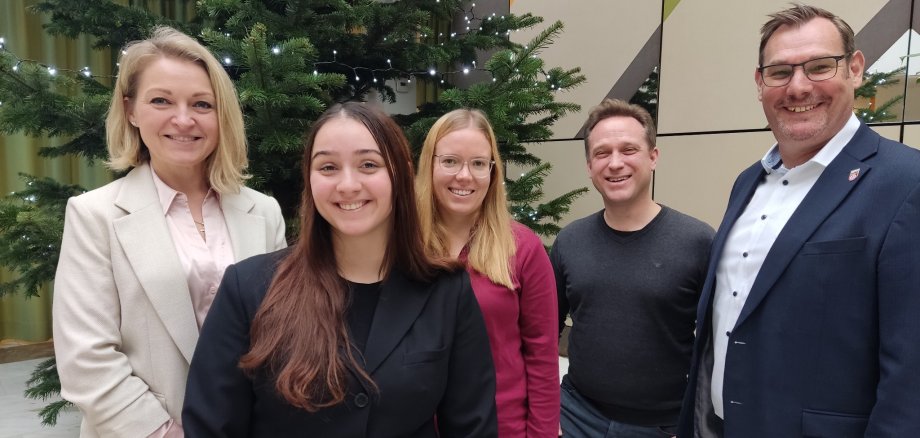 Die neuen Mitarbeiterinnen mit der Rathausspitze vor dem Tannenbaum.