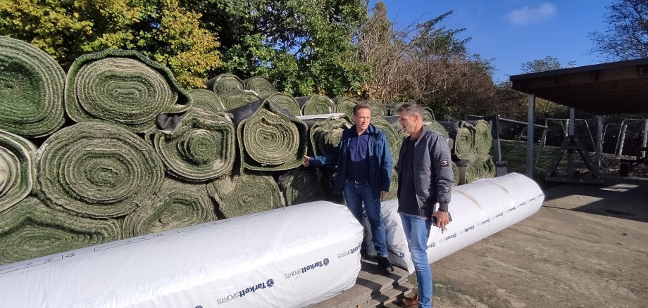 Martin Mohr und Michael Knittel vor den neuen und alten Kunstrasen-Rollen.