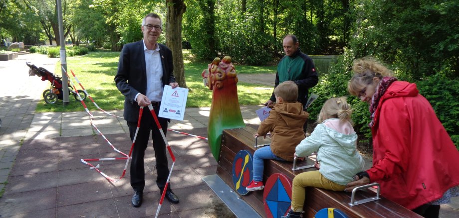 Franz Jirasek vpor dem Drachen im Freizeitpark. Er entfernt Flatterband, Kids sitzen schon auf dem Spielgerät.