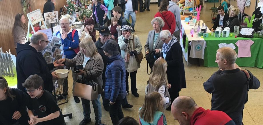 Besucher zwischen Ständen mit Osterdekorationen in der Schwarzbachhalle.