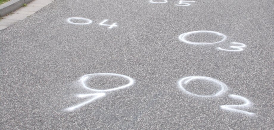 Gesprühte Kreise auf der Fahrbahn nach einem Verkehrsunfall.