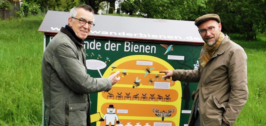 Imker Wolf und der Erstze Beigeordnete Jirasek vor dem bunten Bienenwagen.