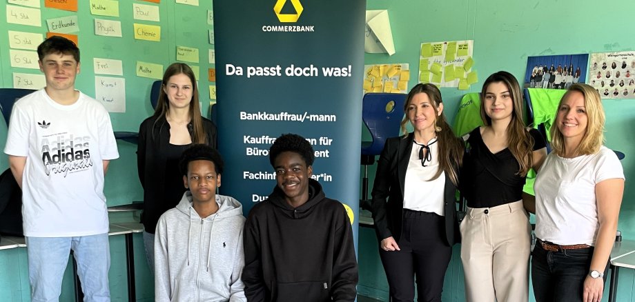 SChülerinnen und Schüler vor Commerzbank-Schild.