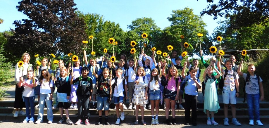 Die neuen Schüler/innen mit ihren Sonnenblumen.