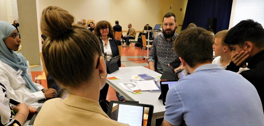 Lehrerin, Politiker und Schüler am Diskussionstisch.