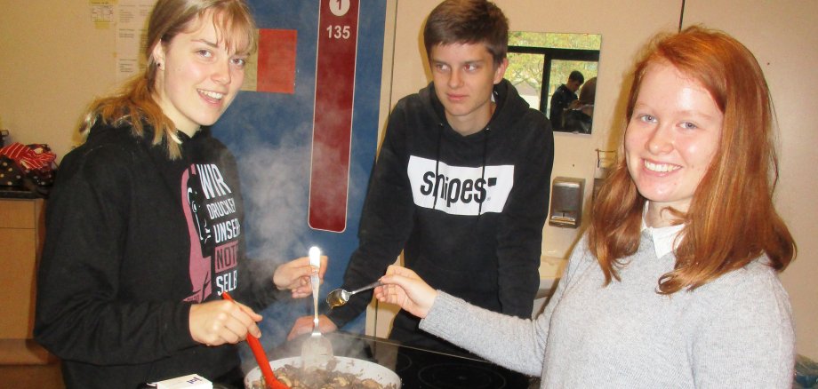 Schüler der Weingartenschule rühren in der Schulküche in einer Pfanne.