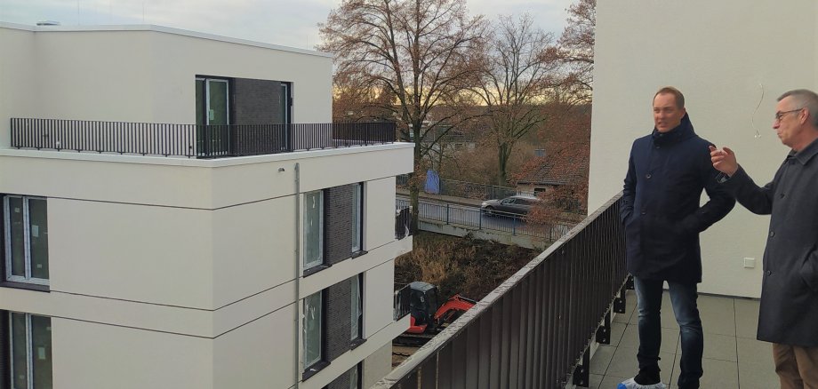 Der Erste Beigeordnete Franz Jirasek auf einem Balkon der neuen Häuser in der Bahnhofstraße.