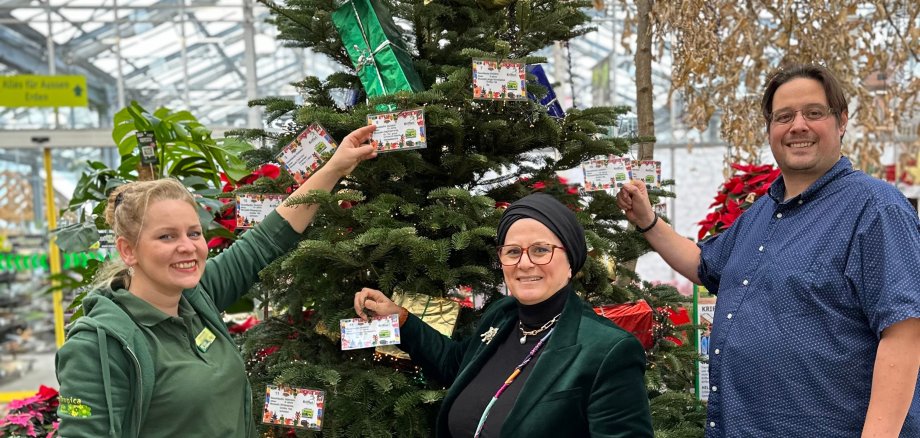 Der geschmückte Tannenbaum mit Initiatoren der Aktion im Tropica.